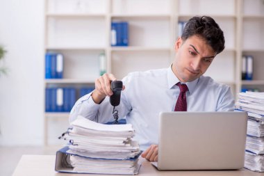 Young employee and too much work at workplace