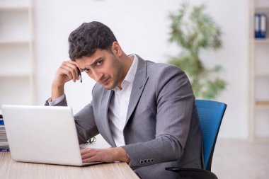 Young employee and too much work at workplace