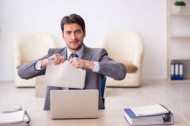 Genç çalışan işyerinde oturuyor.