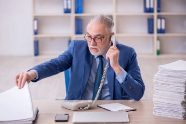 Eski bir işadamı ve işyerinde çok fazla iş var.