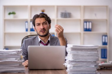 Genç işadamı ve ofiste çok fazla iş var.