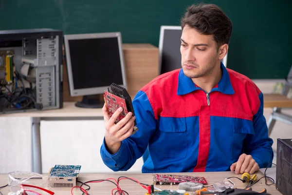 stock image Young repairman repairing computers in the classroom