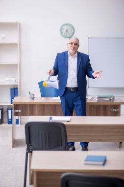 Old teacher holding megaphone in the classroom