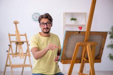 Genç erkek ressam evde resim yapmaktan hoşlanıyor.