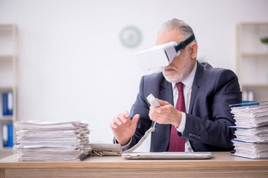 İş yerinde sanal gözlük takan eski bir çalışan.