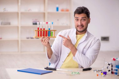 Young chemist sitting at the lab