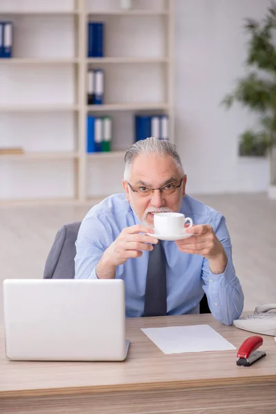 休憩中に古い従業員がコーヒーを飲む — ストック写真