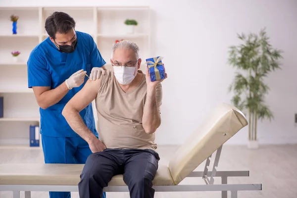 Young Doctor Giving Giftbox Old Male Patient — Stock Photo, Image