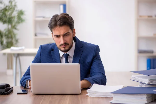 stock image Young businessman employee and too much work in the office