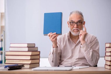 Old teacher sitting in the classroom