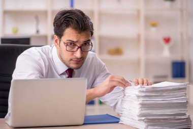 Genç işadamı ve işyerinde çok fazla iş var.