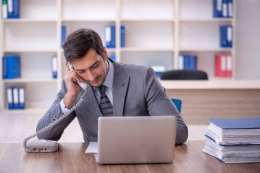 Ofisteki aşırı işten memnun olmayan genç bir çalışan.