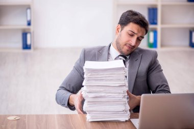 Genç bir çalışan ve ofiste çok fazla iş var.