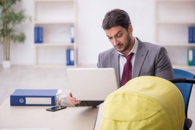 Young employee looking after newborn in the office