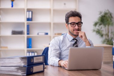 Genç işadamı ve işyerinde çok fazla iş var.