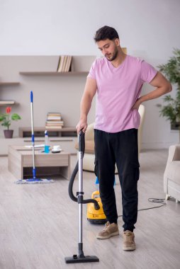 Genç müteahhit evi temizliyor.