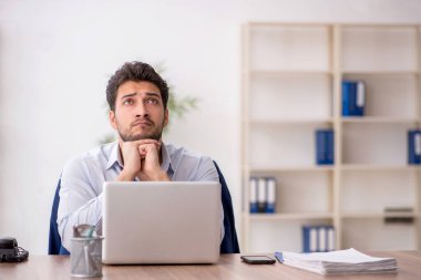 Genç çalışan işyerinde oturuyor.