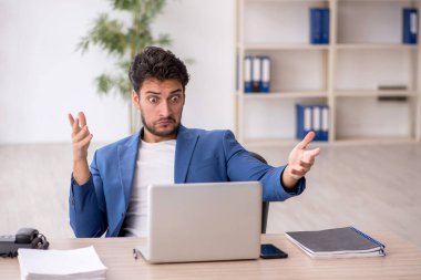 Genç çalışan işyerinde oturuyor.