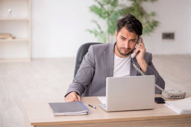 Genç çalışan işyerinde oturuyor.