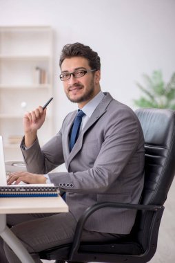 Young employee and too much work at workplace