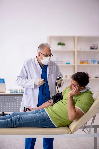 Alter Arzt Misst Jungen Patienten Den Blutdruck — Stockfoto