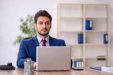 Genç çalışan işyerinde oturuyor.