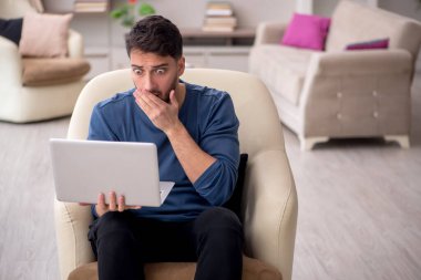 Genç erkek öğrenci salgın sırasında evden çalışıyor.