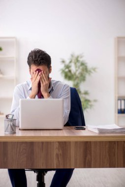 Genç çalışan işyerinde oturuyor.