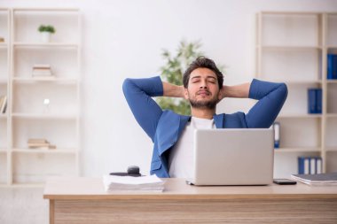 Genç çalışan işyerinde oturuyor.