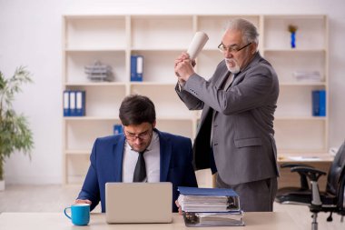 Eski patron ve genç çalışan ofiste.