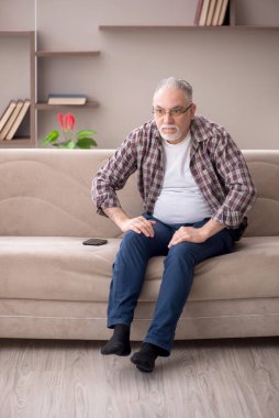 Old man sitting at home during pandemic