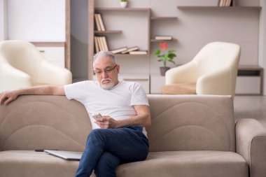 Old man sitting at home during pandemic