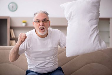 Old man sitting at home during pandemic