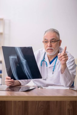 Klinikte çalışan yaşlı bir radyolog.