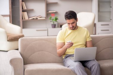 Evde televizyon izleyen genç bir erkek öğrenci.