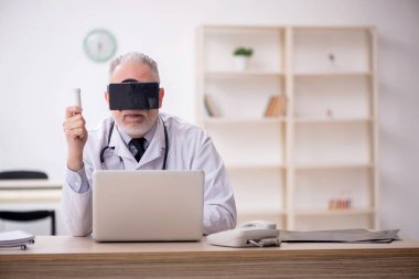 Old doctor wearing virtual glasses at the hospital