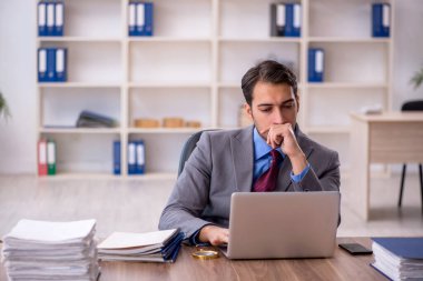 Genç işadamı işyerinde oturuyor.