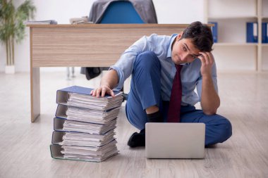 Young employee unhappy with excessive work at workplace