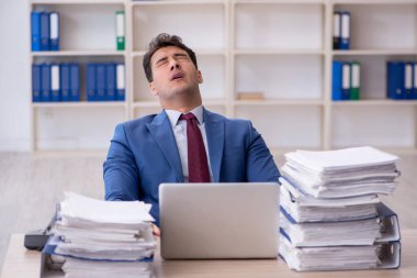 Young employee and too much work at workplace