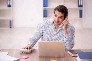 Genç işadamı işyerinde oturuyor.