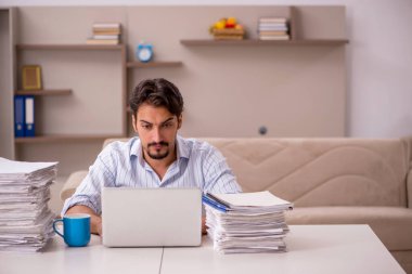 Genç erkek çalışan salgın sırasında evden çalışıyor.