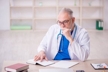 Old doctor sitting at the hospital