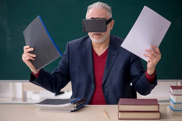 在教室里戴虚拟眼镜的老教师 — 图库照片