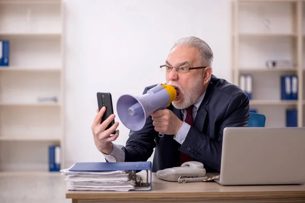 Old businessman employee holding magaphone in the office