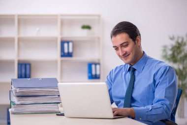 Genç işadamı ve işyerinde çok fazla iş var.