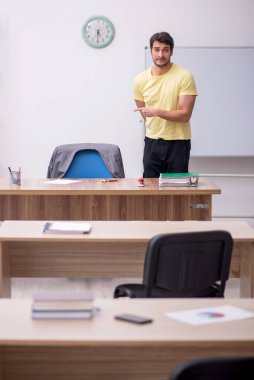 Young student teacher sitting in the classroom