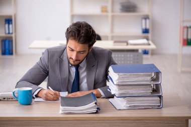 Genç işadamı ve ofiste çok fazla iş var.