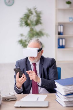 İş yerinde sanal gözlük takan eski bir çalışan.