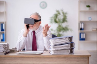 İş yerinde sanal gözlük takan eski bir çalışan.