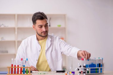 Young chemist sitting at the lab
